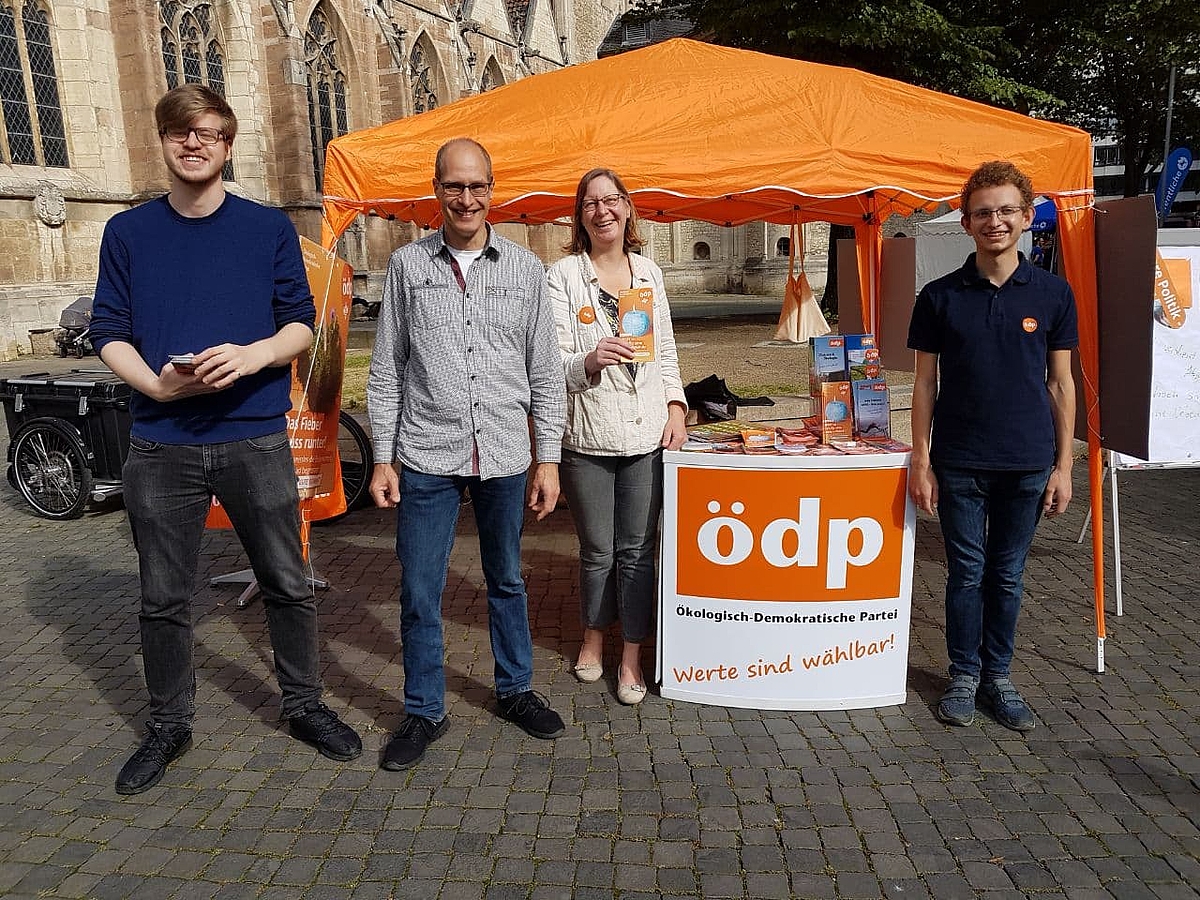 Gruppenfoto mit 4 Leuten vor dem Infostand am Braunschweiger Dom.